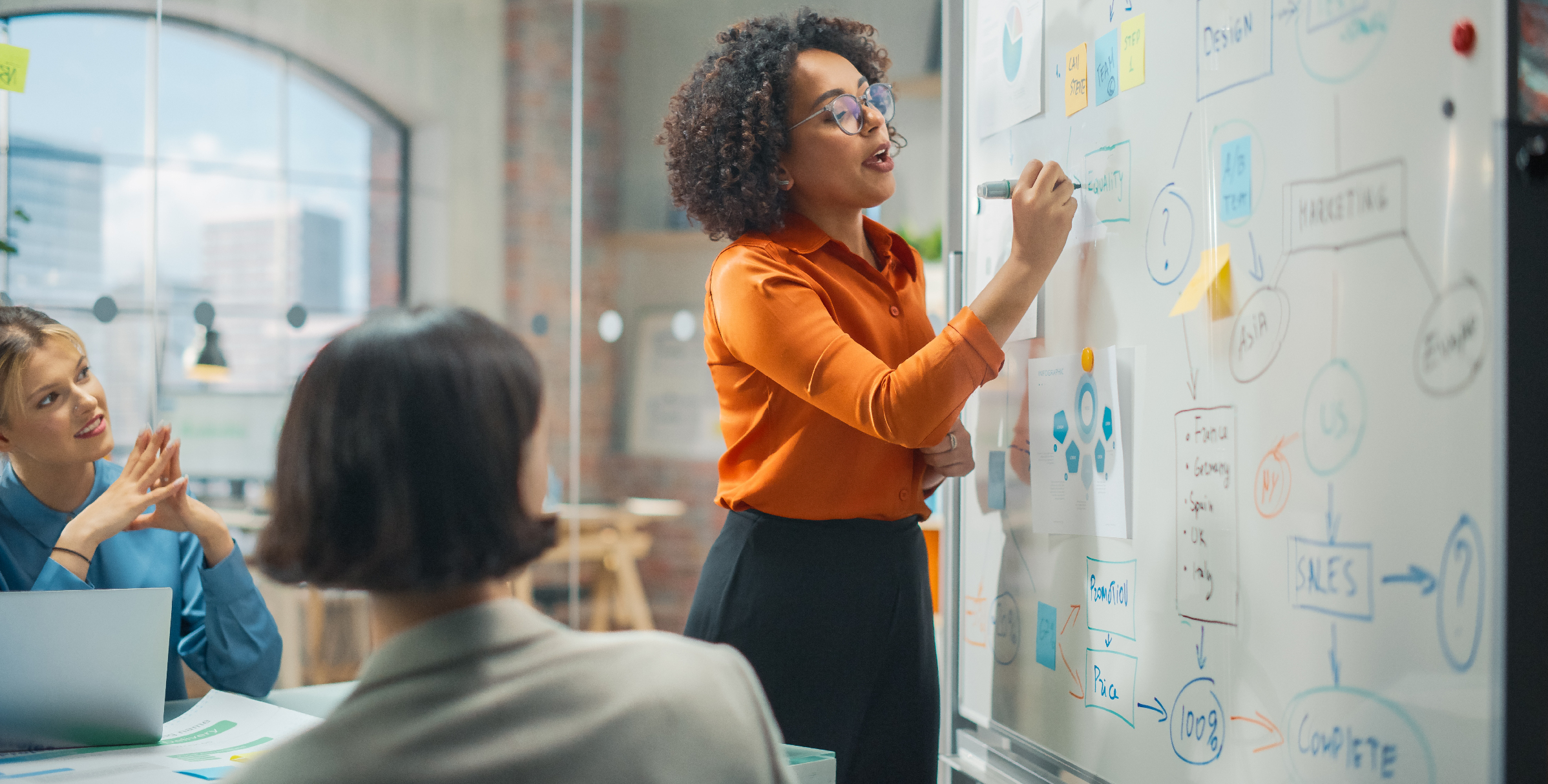 Woman drawing on whiteboard in a meeting