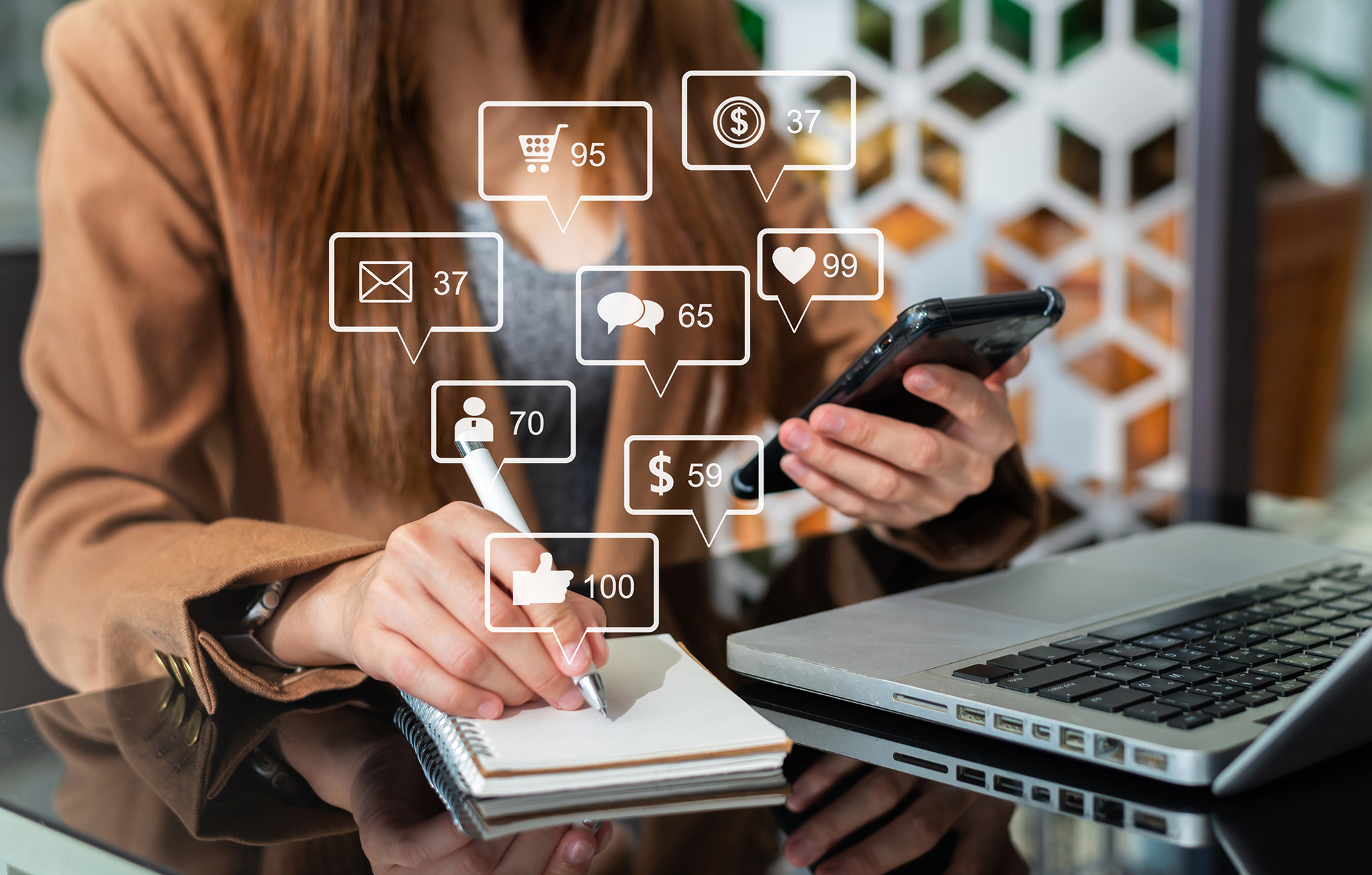 Woman writing notes whilst checking phone notifications